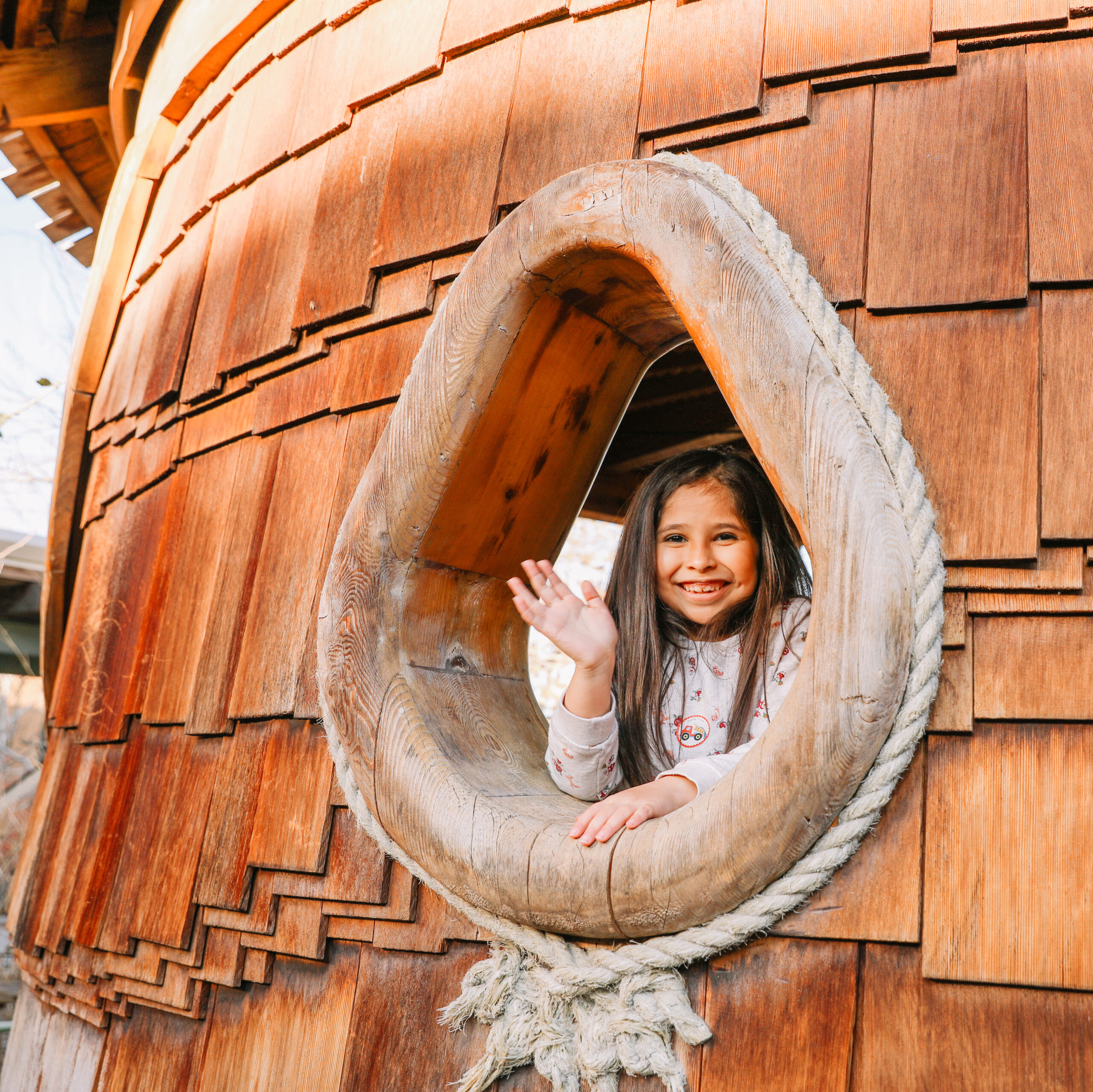 Peeking out of The DoSeum Treehouse, a whimsical exhibit created from reclaimed materials. 